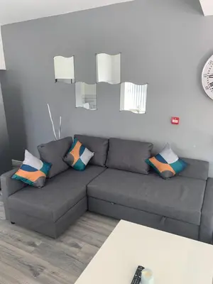 a living room with a gray couch with pillows at Smeaton serviced Accommodation in Liverpool