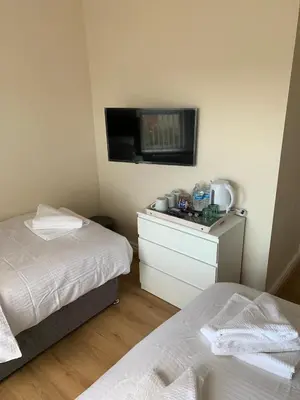 a bedroom with two beds and a tv on the wall at Smeaton serviced Accommodation in Liverpool