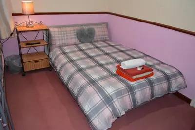 a bedroom with a bed with a red suitcase on it at BLACKPOOL MERCY Inn HOTEL in Blackpool