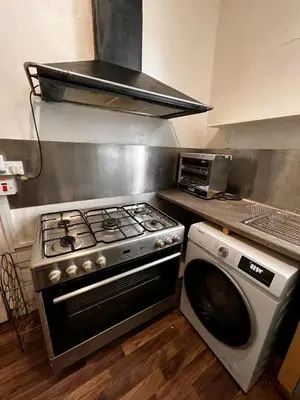 a kitchen with a stove and a washing machine at BLACKPOOL MERCY Inn HOTEL in Blackpool