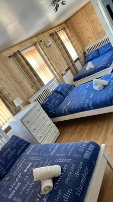 three beds in a room with blue pillows at Fairhaven Hotel on Woodfield Road in Blackpool