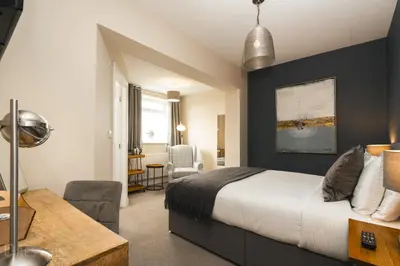a hotel room with a bed and a desk and chair at Rooms at The Dressers Arms in Chorley