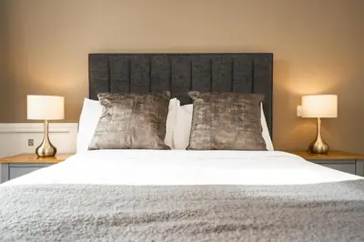 a bedroom with a large bed with two lamps at Rooms at The Dressers Arms in Chorley