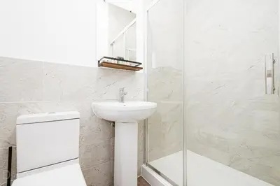 a white bathroom with a sink and a shower at Rooms at The Dressers Arms in Chorley