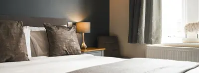 a bedroom with a bed with a lamp and a window at Rooms at The Dressers Arms in Chorley