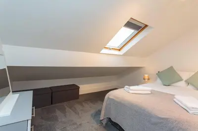 a attic bedroom with a bed with a skylight at Cherry Property - Apple Suite in Blackpool