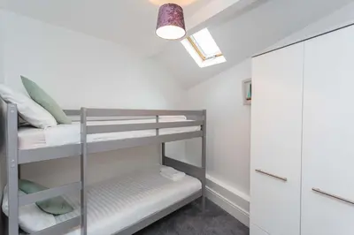 a small room with bunk beds and a closet at Cherry Property - Apple Suite in Blackpool