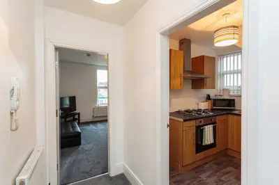 a kitchen with wooden cabinets and a stove top oven at Cherry Property - Apple Suite in Blackpool