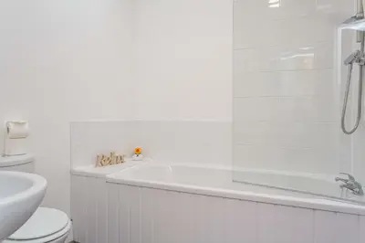 a white bathroom with a tub and a toilet at Cherry Property - Apple Suite in Blackpool