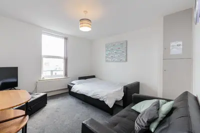 a living room with a bed and a couch at Cherry Property - Apple Suite in Blackpool