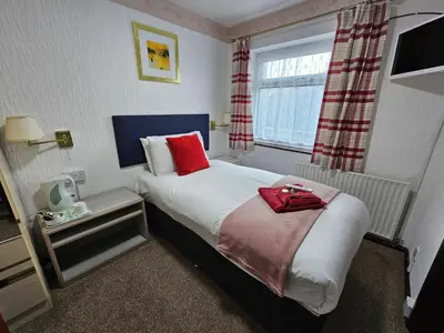a hotel room with a bed and a window at Collingwood Hotel in Blackpool