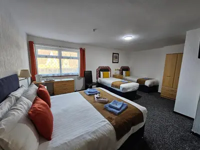 a hotel room with two beds and a couch at Collingwood Hotel in Blackpool