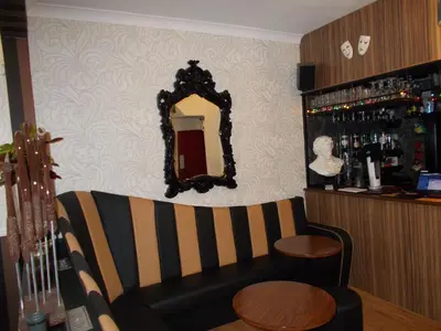 a bar with a couch and a mirror and a guitar at Delamere Hotel in Blackpool