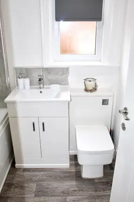 a white bathroom with a toilet and a sink at Reads Jacuzzi Apartments in Blackpool