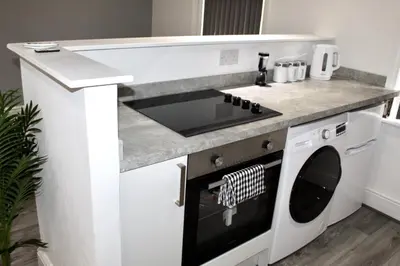 a small kitchen with a stove and a sink at Reads Jacuzzi Apartments in Blackpool