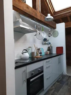 a kitchen with white cabinets and a black counter top at Loftnine9 in Liverpool