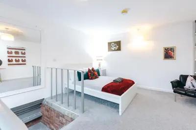 a bedroom with a white bed and a staircase at Loftnine9 in Liverpool