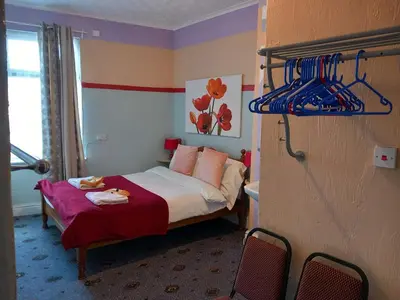 a small bedroom with a bed with a red blanket at My Adam Hotel in Blackpool