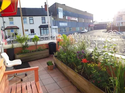 a balcony with flowers and plants on a city street at My Adam Hotel in Blackpool