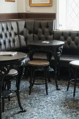 a couch with a table and chairs in a room at Black Dog Inn in Bolton