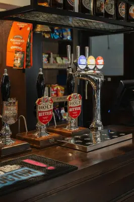 a bar with two glasses of beer on a counter at Black Dog Inn in Bolton