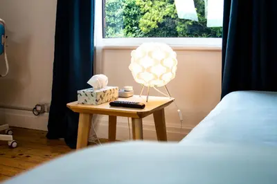 a small table with a bed and a lamp on it at Peaceful House in the Centre of City in Lancaster