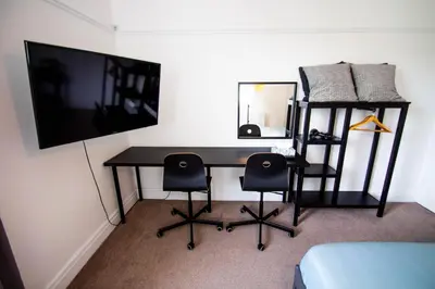 a desk with two chairs and a television in a room at Peaceful House in the Centre of City in Lancaster