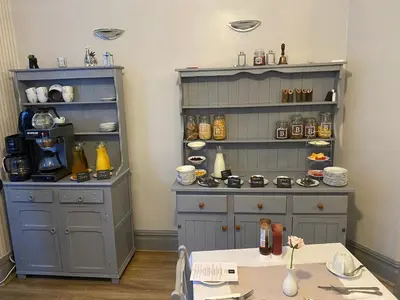 a kitchen with a large cabinet and a table at Bradburys of Blackpool in Blackpool