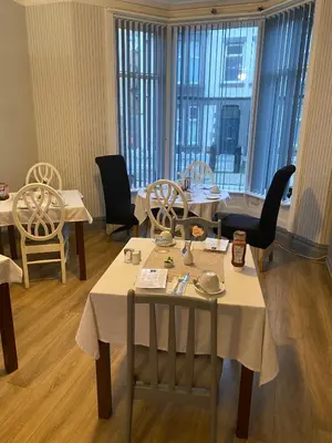 a dining room with tables and chairs and windows at Bradburys of Blackpool in Blackpool