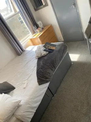 a large bed in a bedroom with a window at Bradburys of Blackpool in Blackpool