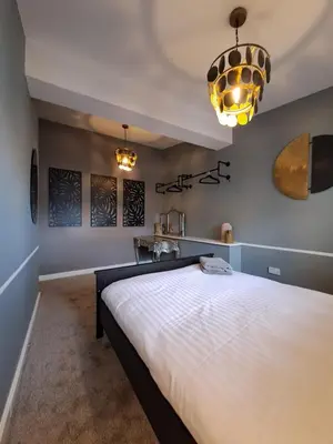 a bedroom with a large bed and a chandelier at Harrington Suite in Liverpool