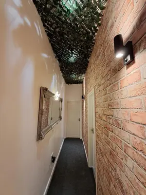 a hallway with a brick wall and a mirror at Harrington Suite in Liverpool