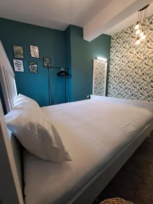 a bedroom with a large white bed with blue walls at Harrington Suite in Liverpool