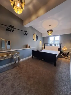 a bedroom with a bed and a dressing table and a mirror at Harrington Suite in Liverpool
