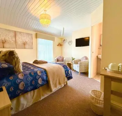 a bedroom with two beds and a television in it at The Copplehouse in Southport