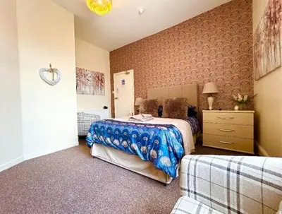 a bedroom with two beds and a dresser at The Copplehouse in Southport