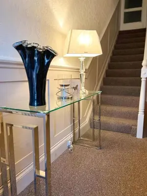 a glass table with a blue vase on top of it at The Copplehouse in Southport