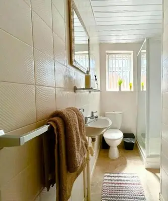 a bathroom with a sink and a toilet and a mirror at The Copplehouse in Southport