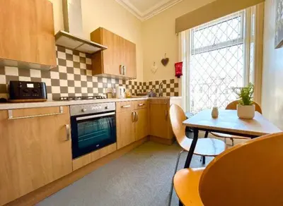 a kitchen with wooden cabinets and a table with a tableablish at The Copplehouse in Southport