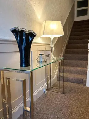 a glass table with a blue vase on top of it at The Copplehouse in Southport
