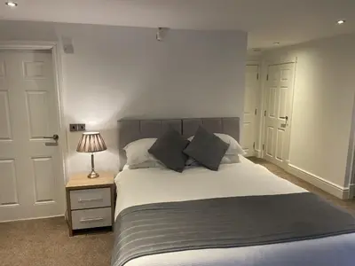 a bedroom with a bed and a lamp on a night stand at Beach House Courtyard 1 bed in Southport