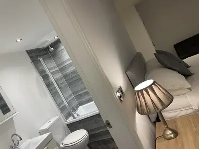 a small bathroom with a bed and a window at Beach House Courtyard 1 bed in Southport
