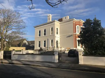 a white house with a car parked in front of it at Beach House Courtyard 1 bed in Southport