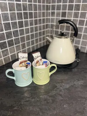 two coffee cups sitting on a counter with a tea kettle at Beach House Courtyard 1 bed in Southport