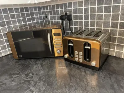 a microwave and a toaster oven sitting on a counter at Beach House Courtyard 1 bed in Southport