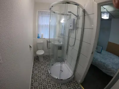a bathroom with a shower and a toilet and a sink at Granville Hotel in Blackpool
