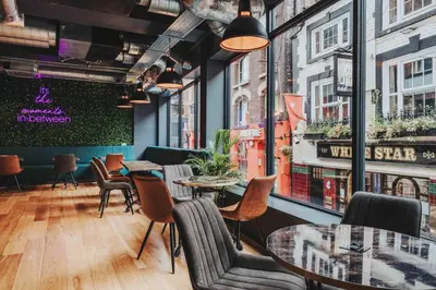 a restaurant with tables and chairs and windows at Kabannas Liverpool in Liverpool