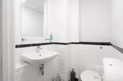 a white bathroom with a sink and a toilet at Kabannas Liverpool in Liverpool