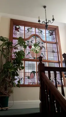 a stained glass window with a plant in front of it at The Breverton in Lytham St Annes