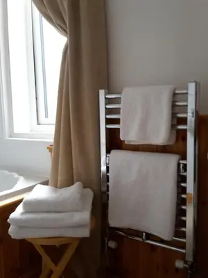 a towel rack with towels on it next to a window at The Breverton in Lytham St Annes